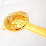 gold hawthorne strainer long This traditional Hawthorne-style strainer is distinctive with its long handle and heavy weight. Shake or stir your cocktail, and the tight coil helps to better strain out ice and any other ingredients as you pour the drink into a glass.